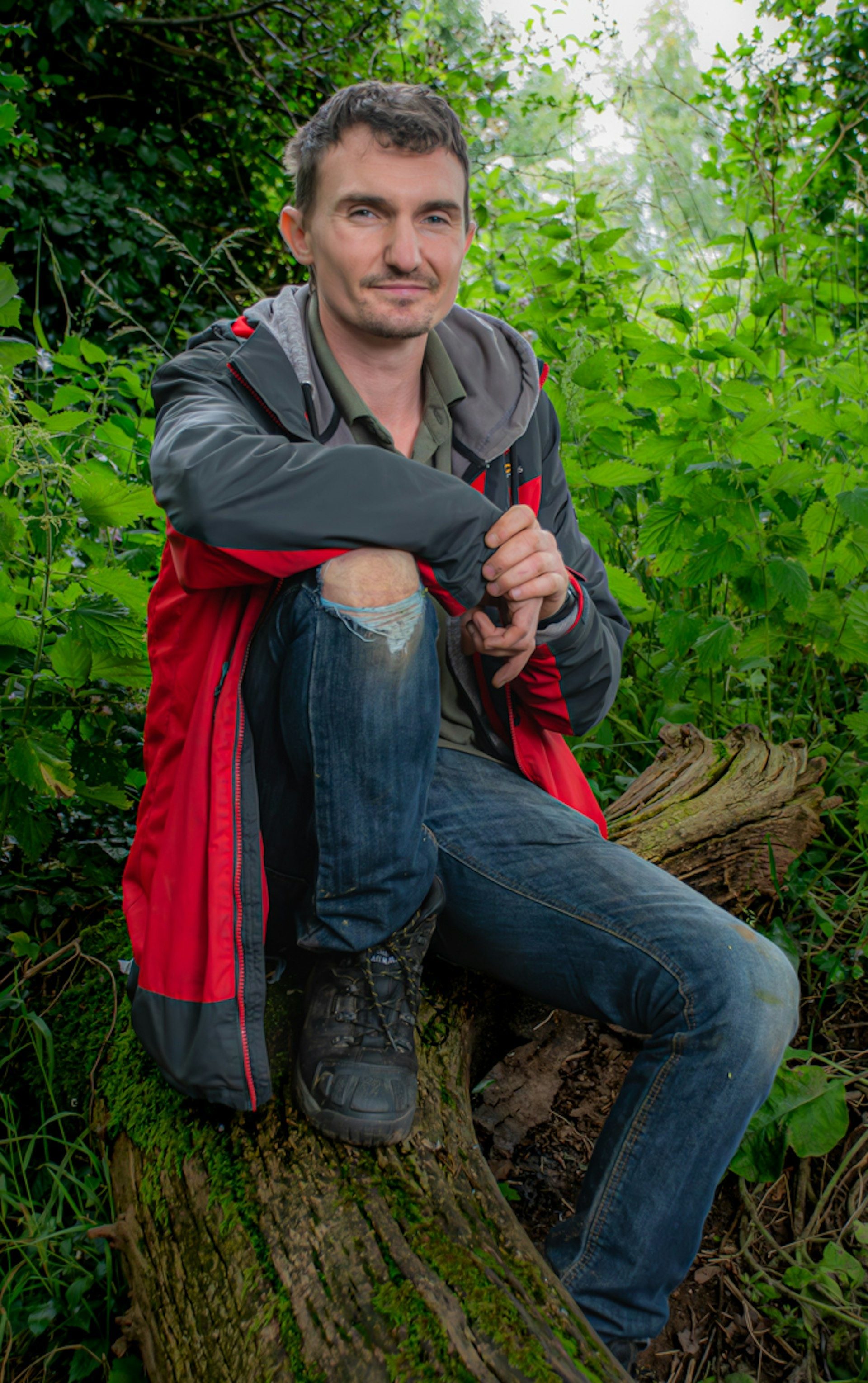 Bushcraft instructor sits among the undergrowth