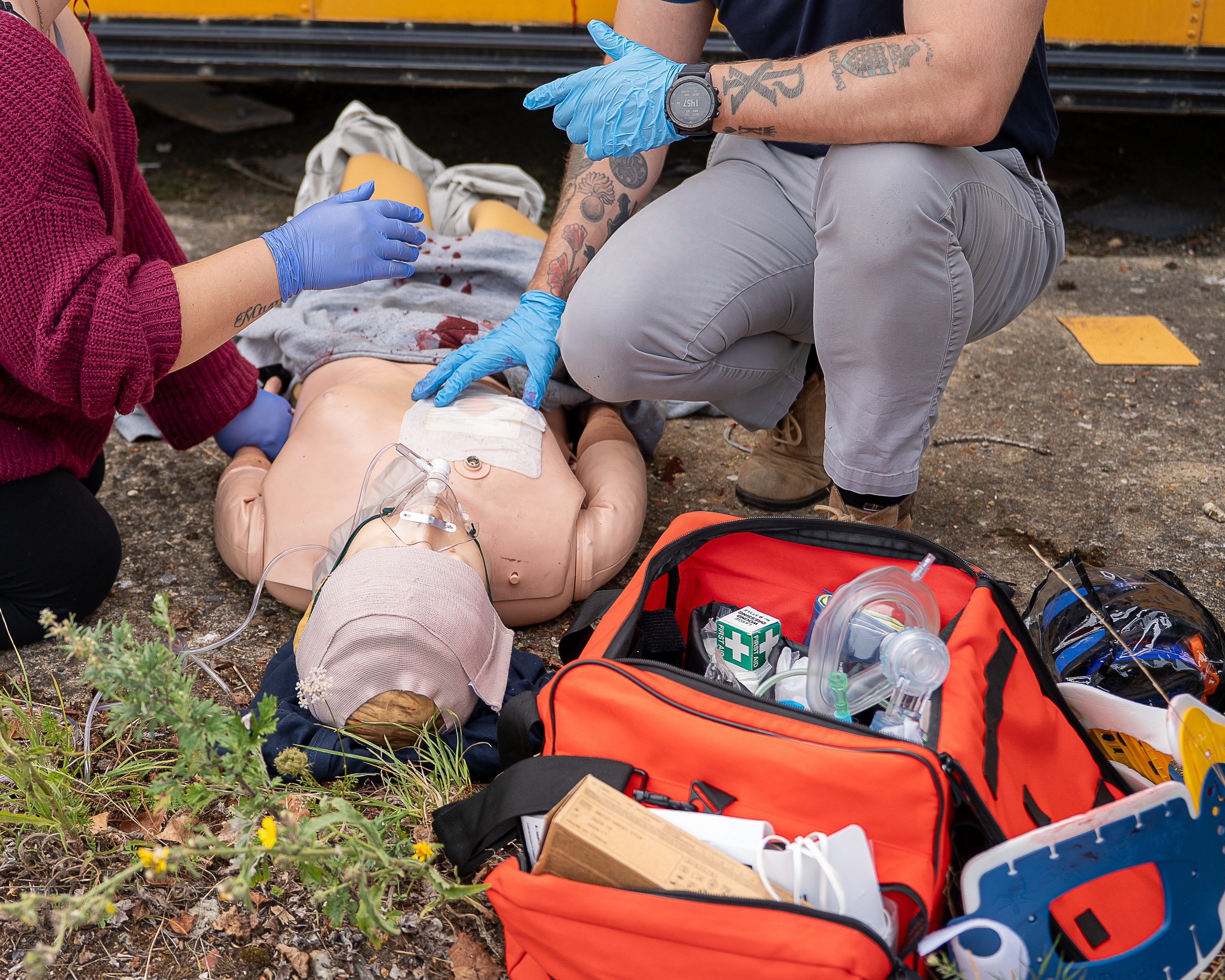 Trainee practises CPR on a mannequin beside the school bus