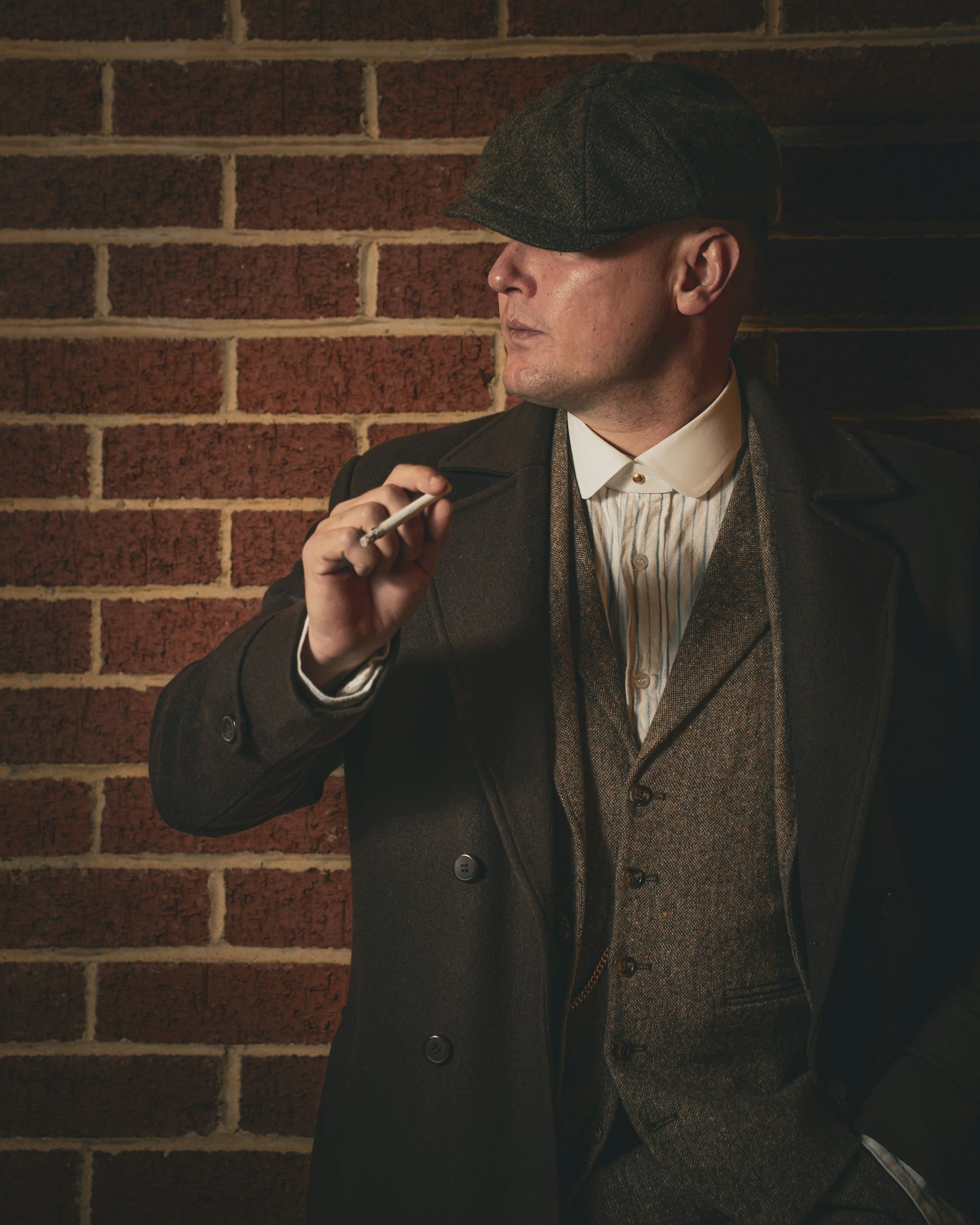 Profile of a man in a flat cap and overcoat