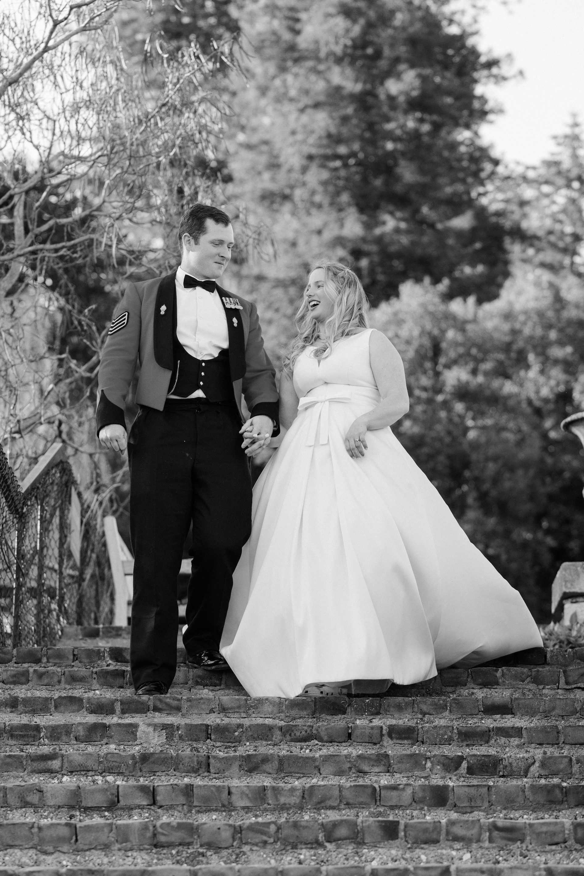 Bride and groom descend the garden steps, in black and white