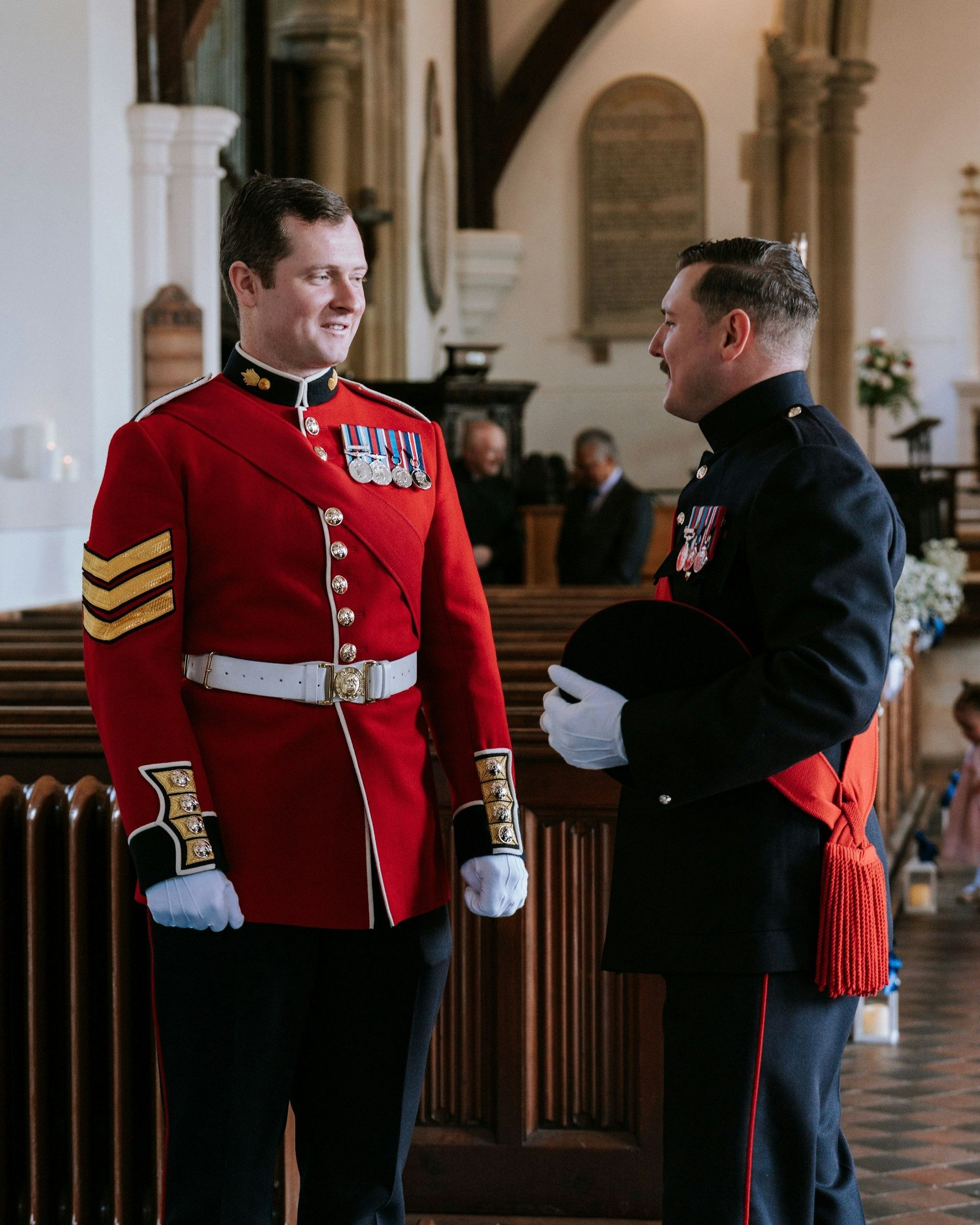 Groom and best man in military dress uniform wait at the front of the church