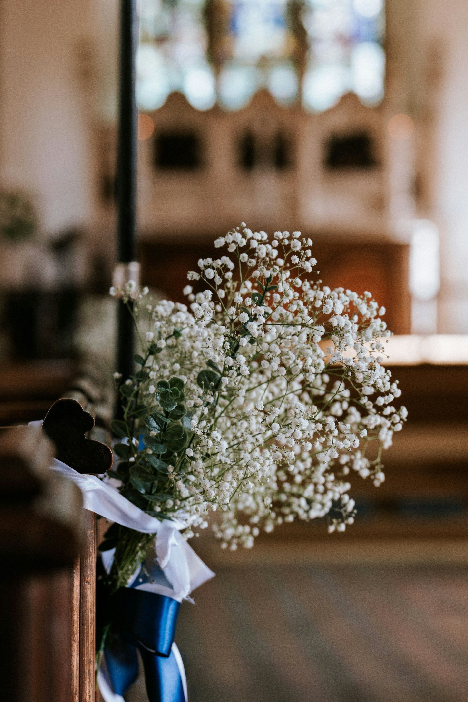 Gypsophila and blue ribbon tied to a church pew