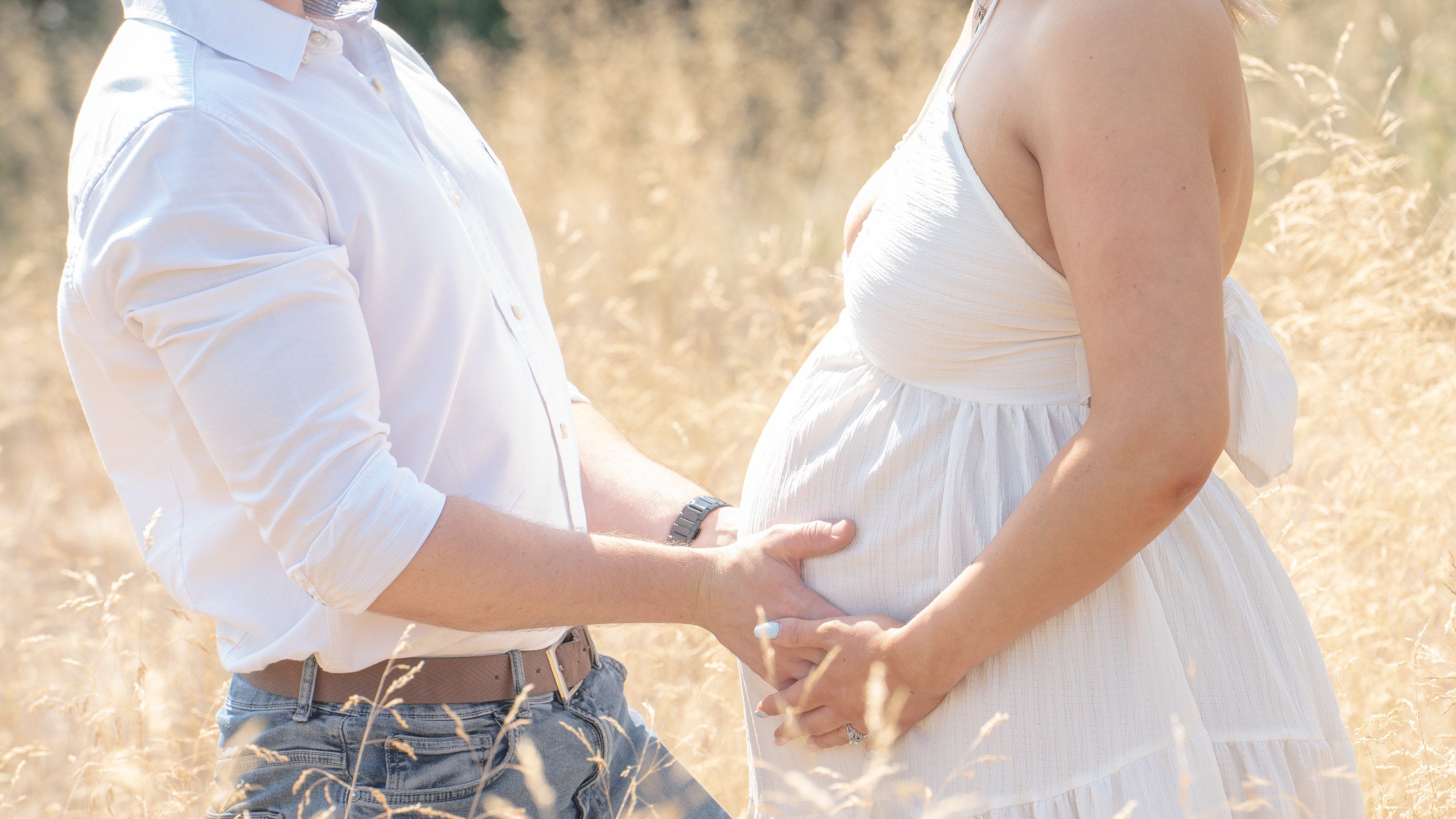 Couple’s hands rest together on her bump