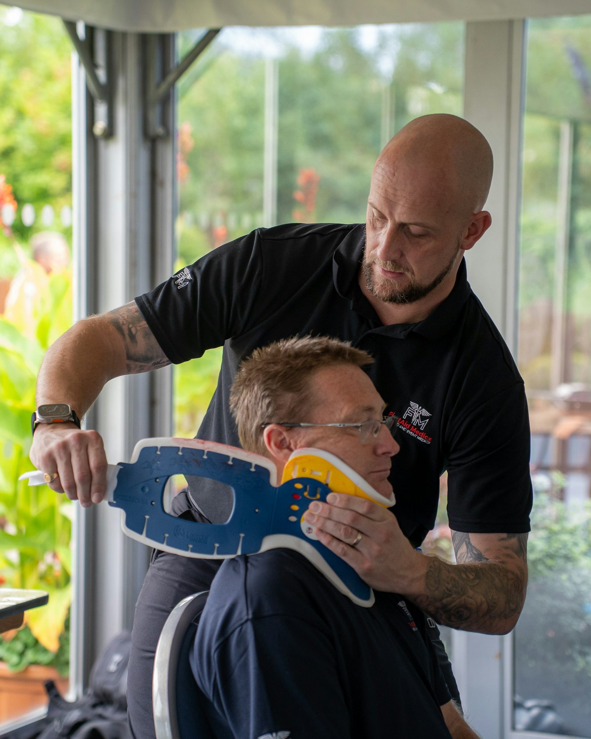 Instructor fits a neck brace on a volunteer