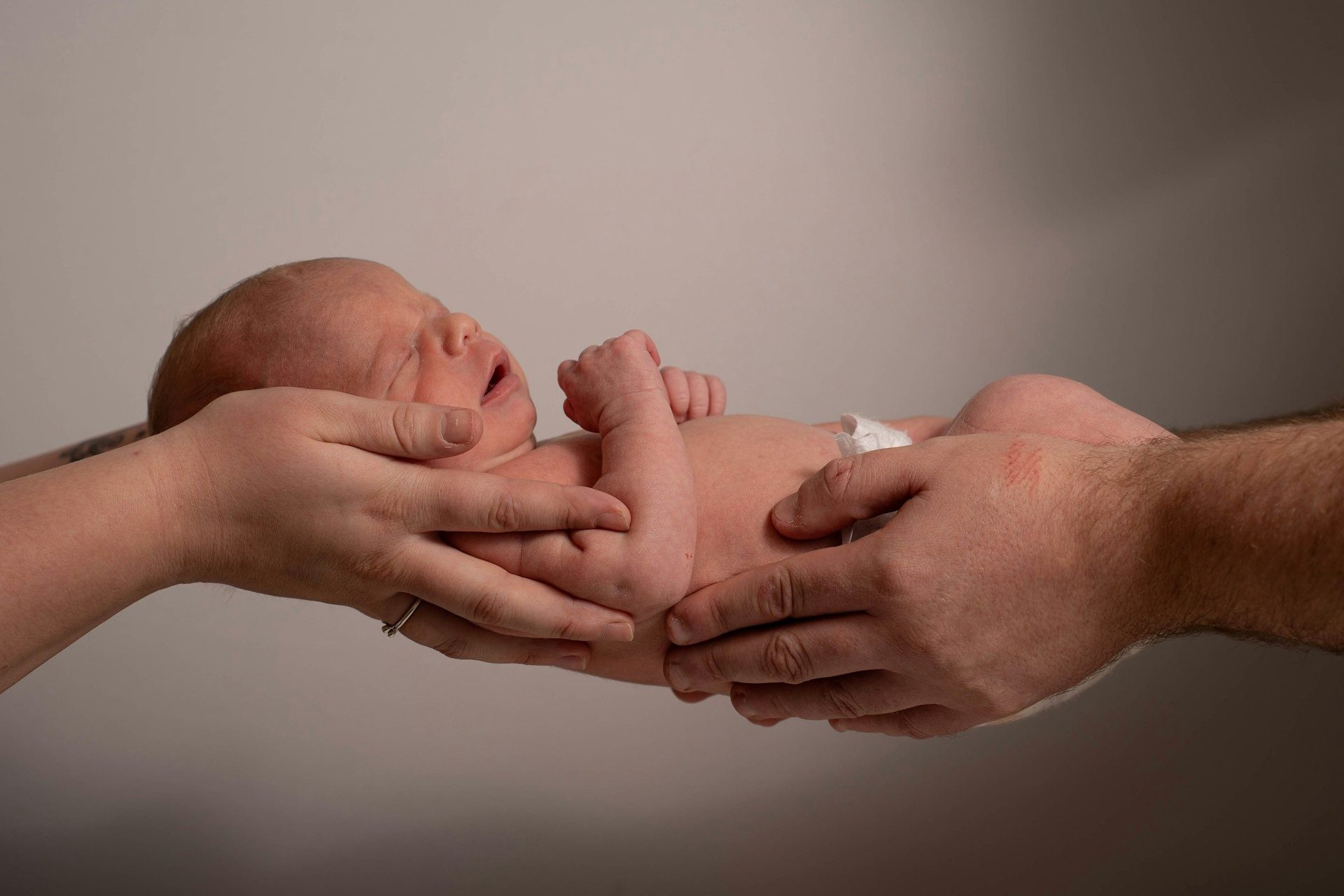 Newborn cradled in two hands