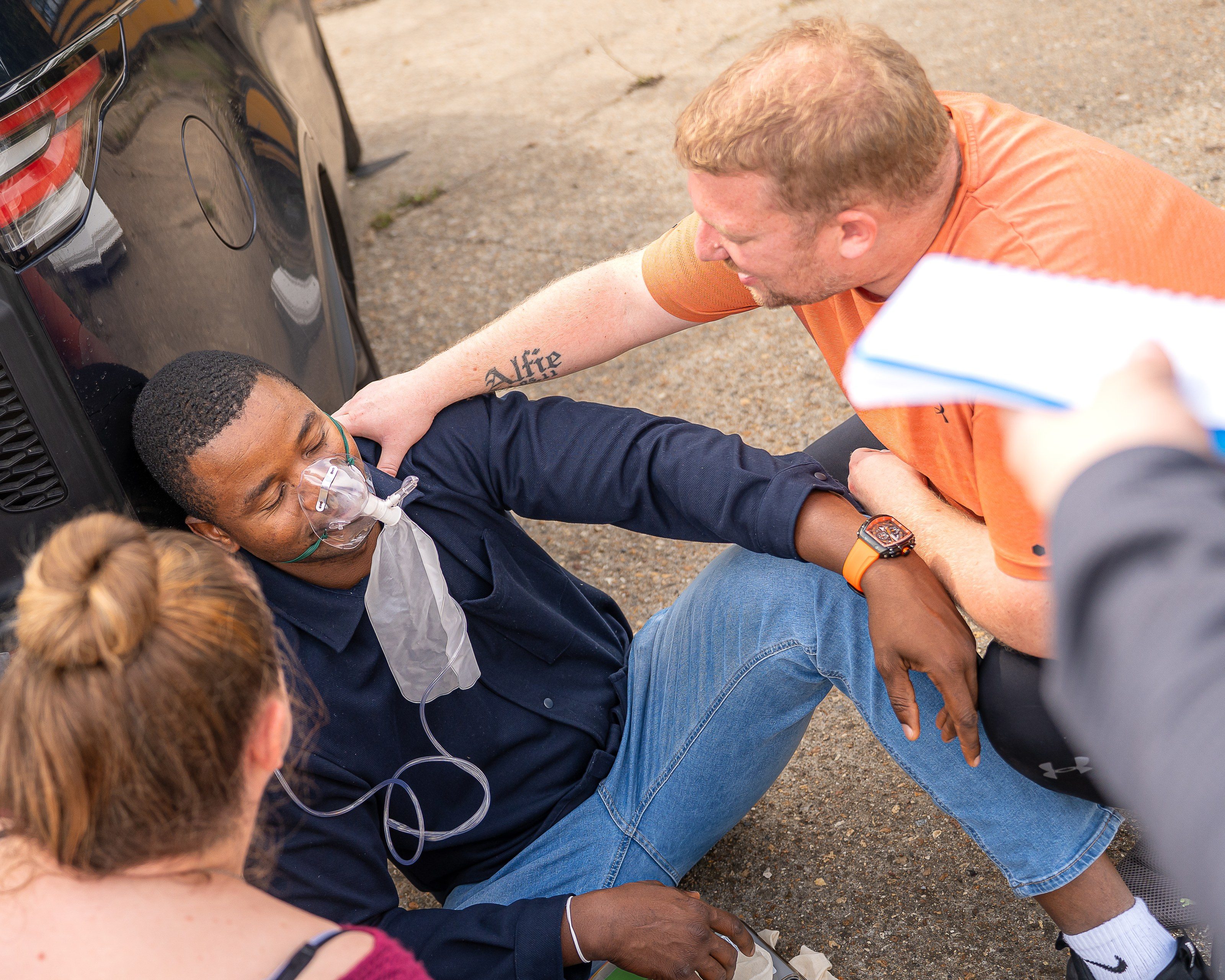 Trainee fits an oxygen mask to a seated casualty