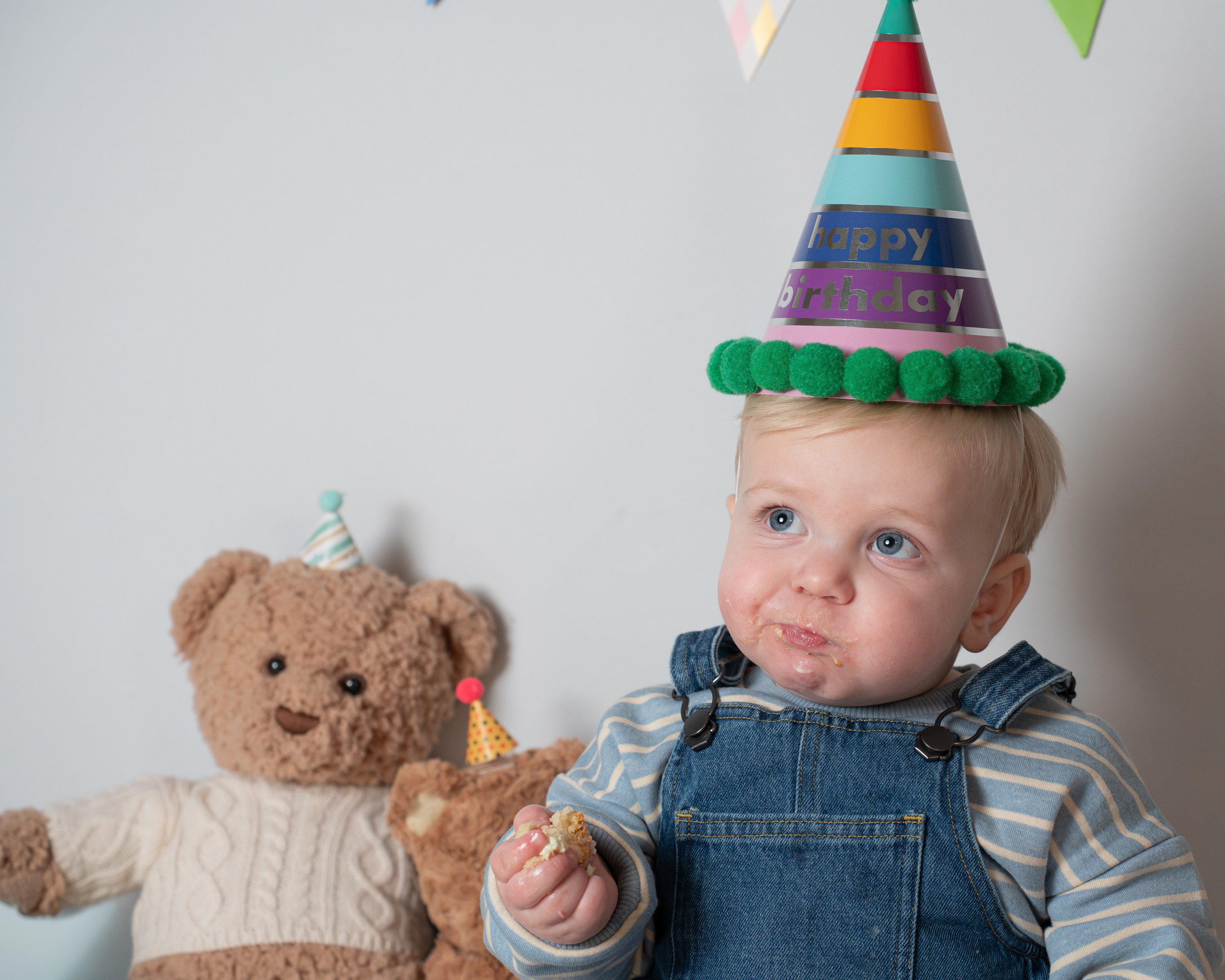 Toddler in a rainbow party hat