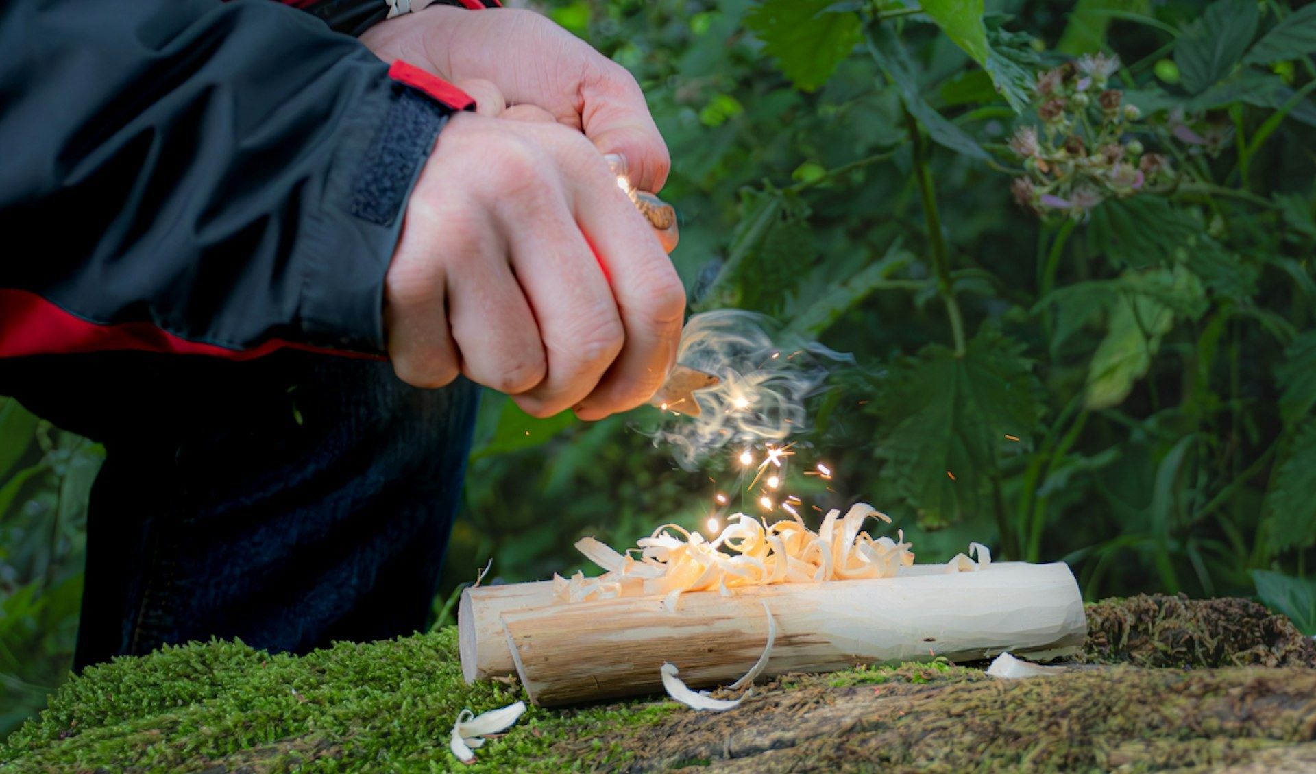 Sparks from a ferro rod catch the tinder