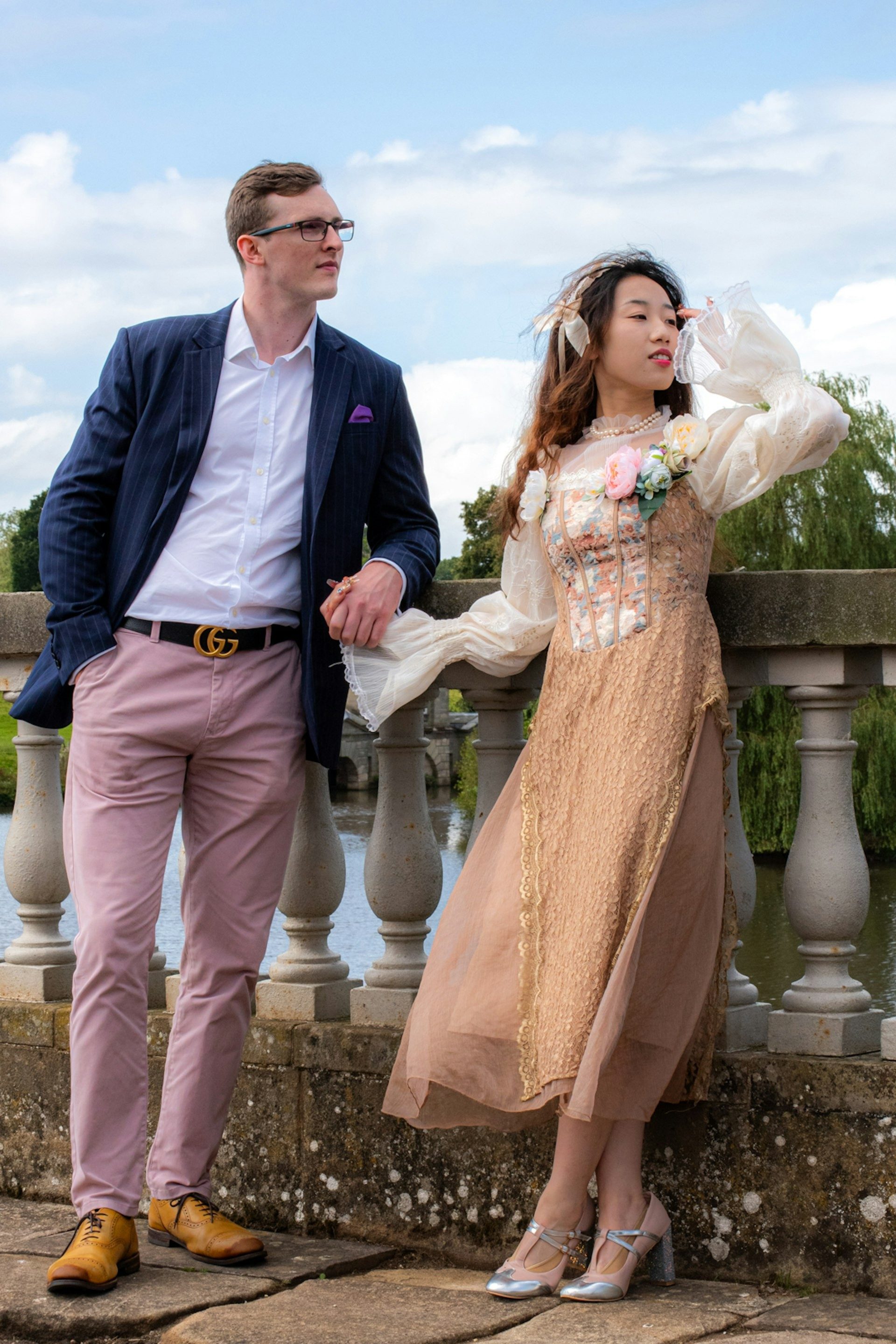 Bride and groom pose at a stone balustrade