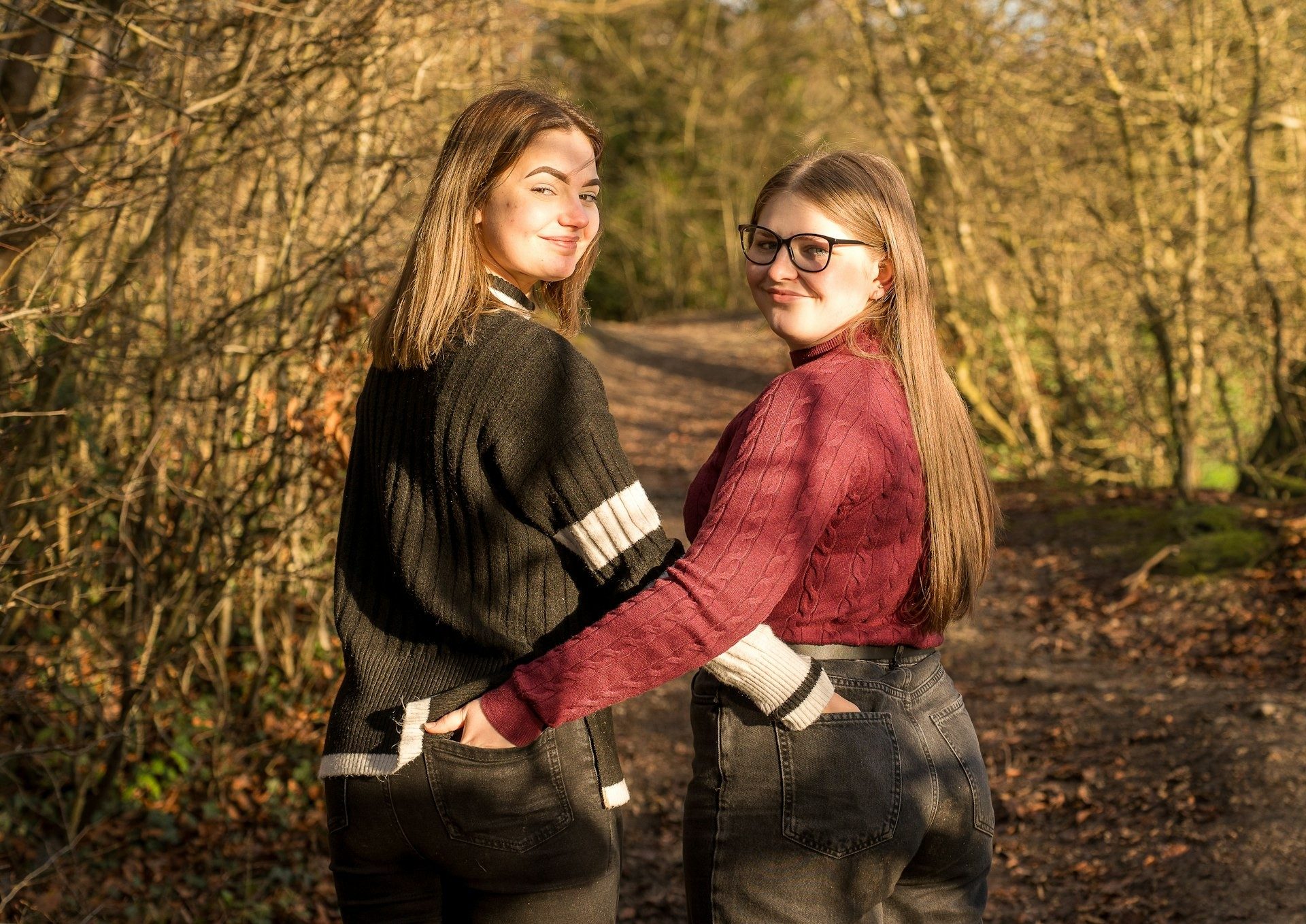 Two friends look back along a woodland path